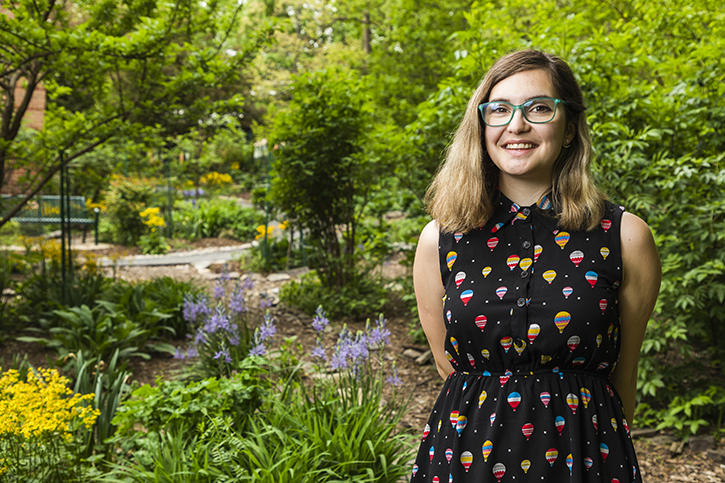 Portrait of Eleri Burnett. She is wearing glasses and a dress with hot air balloons depicted on the fabric.