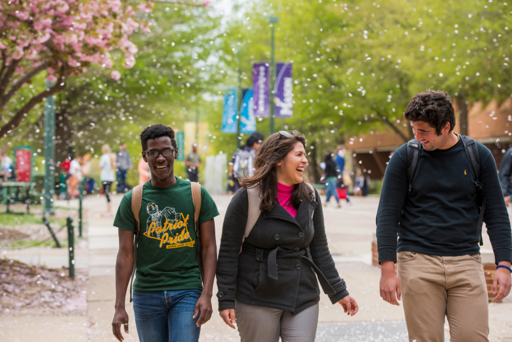 Three students walking on campus in Spring