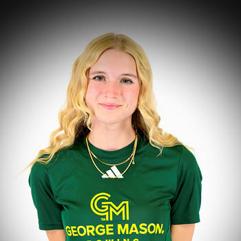 A woman with long blond hair in a green T-shirt smiles at the camera.